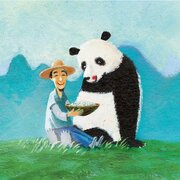 Fröhlicher Mann mit Strohhut sitzt auf einer Wiese und füttert einen großen Panda aus einer Schale.  | © SONNENTOR