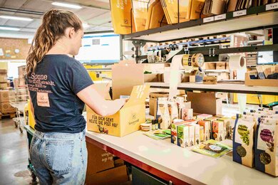 The ordered products are packed by hand into our sunny yellow shipping carton. | © SONNENTOR