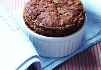 Auf dem Foto ist ein Schokoladen-Lebkuchen-Soufflé zu sehen. Das Förmchen steht auf einer blauen Serviette. | © SONNENTOR