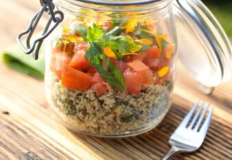 Foto von einem Glas Cous Cous Taboulé Salat auf einem Holztisch. Daneben liegt eine Gabel. | © SONNENTOR