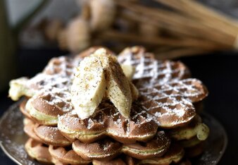 Auf dem Foto sind vier übereinander liegende Waffeln zu sehen. Garniert mit Bananenscheiben und Gewürzen. | © SONNENTOR