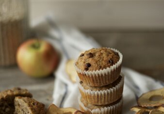 Auf dem Foto sind drei Müslimuffins zu sehen. Daneben liegen Apfelringe und auch frische Äpfel. | © SONNENTOR