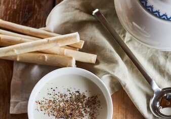 Auf dem Foto ist eine Tasse mit Spargelcreme Suppe zu sehen. Daneben ist frischer Spargel zu sehen. | © SONNENTOR