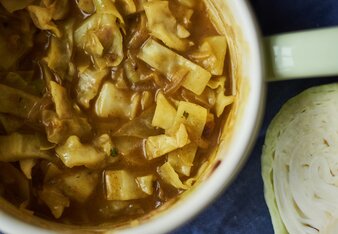 Auf dem Foto ist ein Topf mit Kraut liebt Curry Eintopf zu sehen. Daneben sieht man noch frisches Kraut. | © SONNENTOR