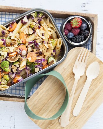 Auf dem Foto ist eine Form mit buntem Pasta-Gemüse-Salat zu sehen. Daneben steht auch ein Glas mit frischen Beeren. | © SONNENTOR