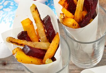 Auf dem Foto sind zwei Papiertüten mit Gemüse Pommes zu sehen. Im Hintergrund sieht man ein Schälchen mit Tomatendip. | © SONNENTOR