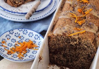 Auf dem Foto ist eine Backform mit Mohn-Karotten Kuchen zu sehen. Daneben steht ein Teller auf dem bereits ein Stück Kuchen liegt. | © SONNENTOR