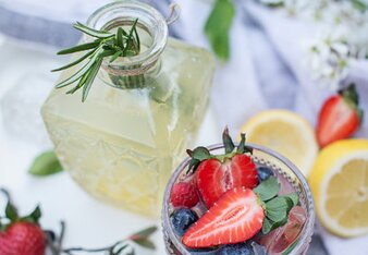 Auf dem Foto ist ein Glas Beeren "Gin" Fizz zu sehen. Darin sind Erdbeeren und Heidelbeeren zu sehen.  | © SONNENTOR