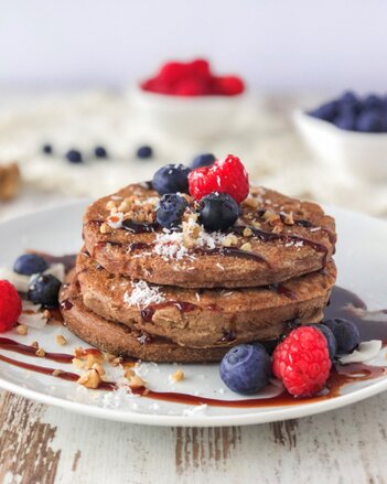 Auf dem Foto sind mehrere Buchweizen Pancakes übereinander zu sehen. Die Pancakes sind mit frischen Beeren und Nüssen garniert. | © SONNENTOR