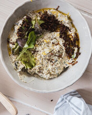 Auf dem Foto ist eine weiße Schüssel mit dem Champignon-Kräuter Aufstrich zu sehen. Er ist mit frischem Salat garniert. | © SONNENTOR