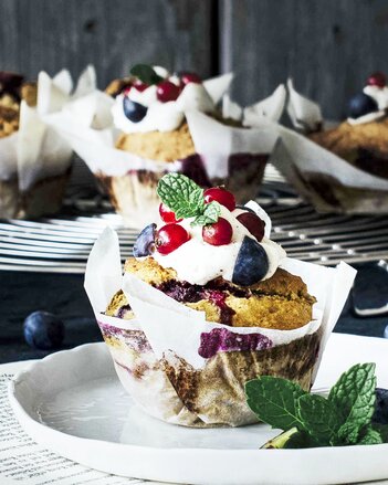 Auf dem Foto sind Heidelbeermuffins zu sehen. Auf der Frischkäse-Honig Haube sind frische Beeren zu sehen. | © SONNENTOR