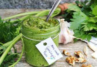 Auf dem Foto ist ein Glas mit Gemüsegrün Pesto zu sehen. Neben dem Glas sind Petersilie, Knoblauch und Walnüsse zu sehen. | © SONNENTOR