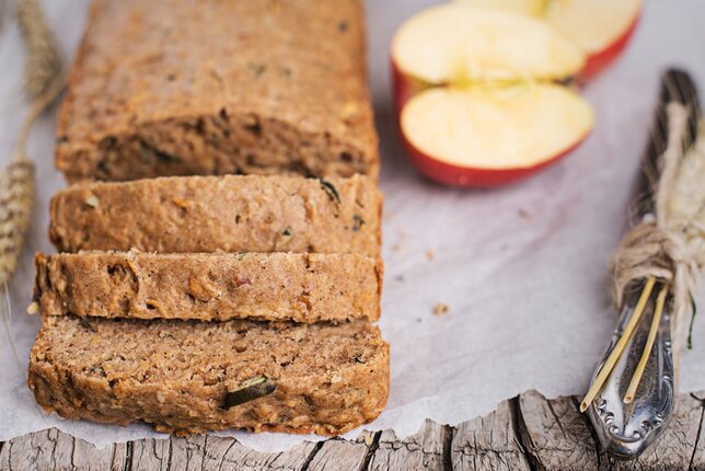 Auf dem Foto ist aufgeschnittenes Brot zu sehen. Daneben liegen Apfelhälften. | © SONNENTOR