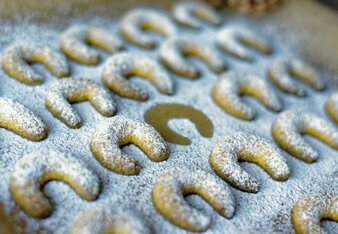 Auf dem Foto ist ein Blech mit Vanille-Kurkuma Kekse zu sehen. Sie sind mit Staubzucker übersehen. | © SONNENTOR