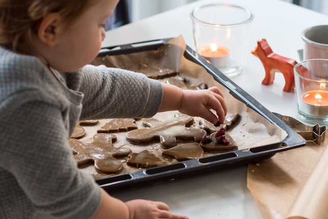 Auf dem Foto sieht man wie ein Kind Lebkuchen mit Rosinen verfeinert. | © SONNENTOR