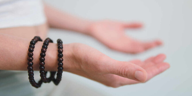 Auf dem Foto sieht man die Hände einer Frau mit den Handflächen nach oben gerichtet. Sie trägt drei Armbänder aus Holzkugeln. | © SONNENTOR